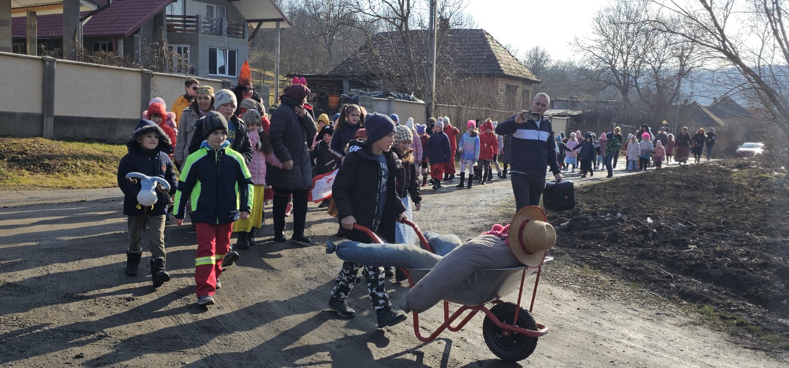 A jelmezes gyereksereg az utcán vonul a hangos népzenére